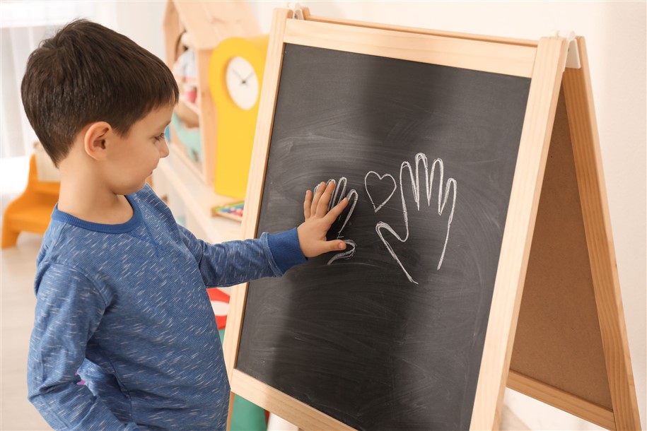 Image of Child Tracing Hand on Chalkboard
